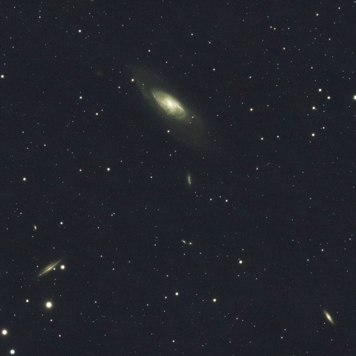 The giant spiral galaxy M106 looks relatively small in the top-centre of this image, with the six other visible galaxies appearing smaller still at their immense distances from us
