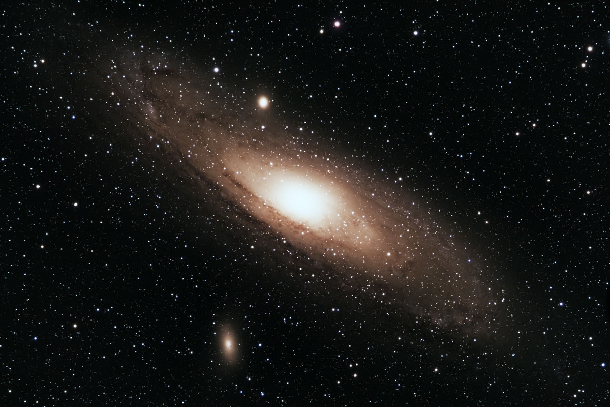 The Andromeda galaxy, showing dust lanes and nebulae in the spiral arms, with its two sattelite dwarf galaxies M32 and M110